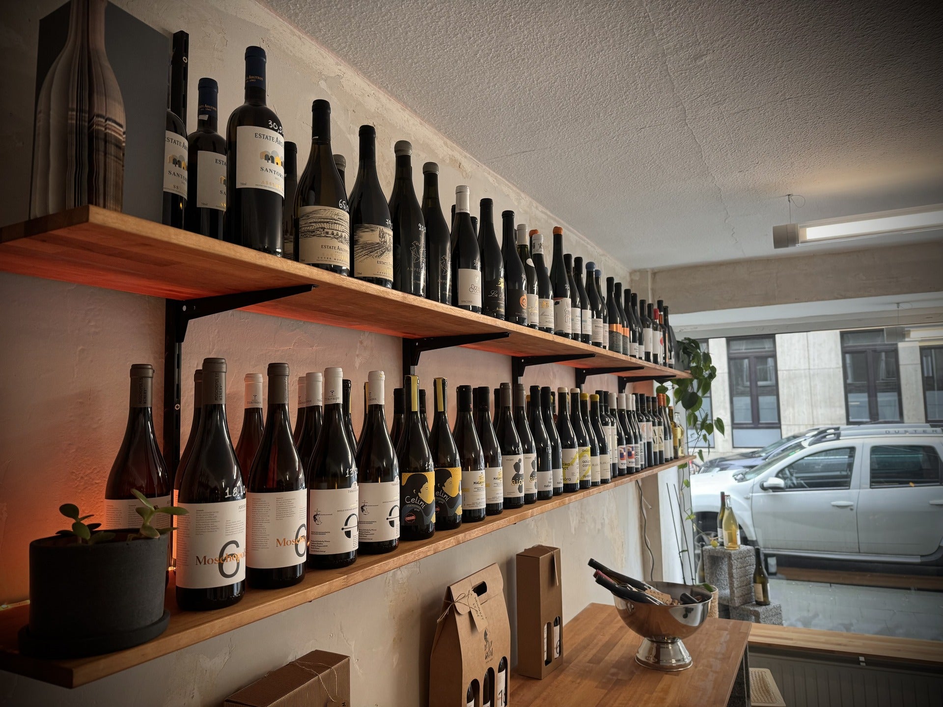 Präsentation der Weißweinsammlung in der Weinhandlung Holy Grail. Die ansprechende Anordnung der Flaschen auf Regalen zeigt eine Auswahl an hochwertigen Weißweinen, umgeben von eleganten Dekorationen, die eine einladende Atmosphäre schaffen.