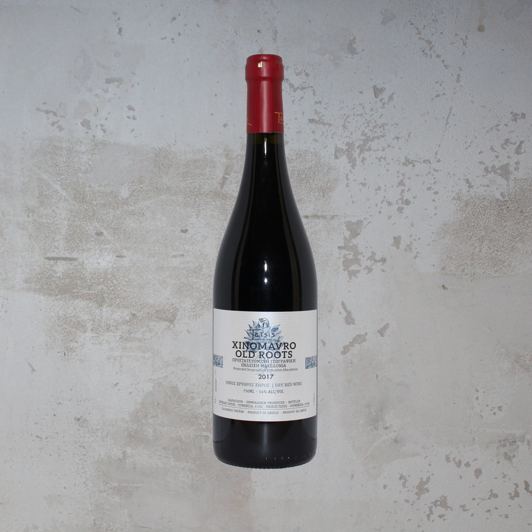 Flasche Domaine Tatsis Xinomavro Old Roots 2017 BIO. Die elegante Flasche zeigt ein ansprechendes Etikett mit stilvoller Schrift und einem klassischen Design, das die tiefen und komplexen Aromen dieses biologisch angebauten griechischen Rotweins aus alten Xinomavro-Reben hervorhebt.