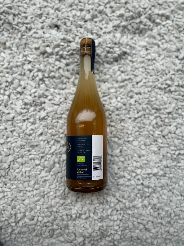 Flasche Hidcote Blue 0.00% von København Kombucha. Die schlanke Flasche hat ein minimalistisches Design mit einem blauen Etikett, das die alkoholfreie und erfrischende Natur der Kombucha-Getränksorte betont.