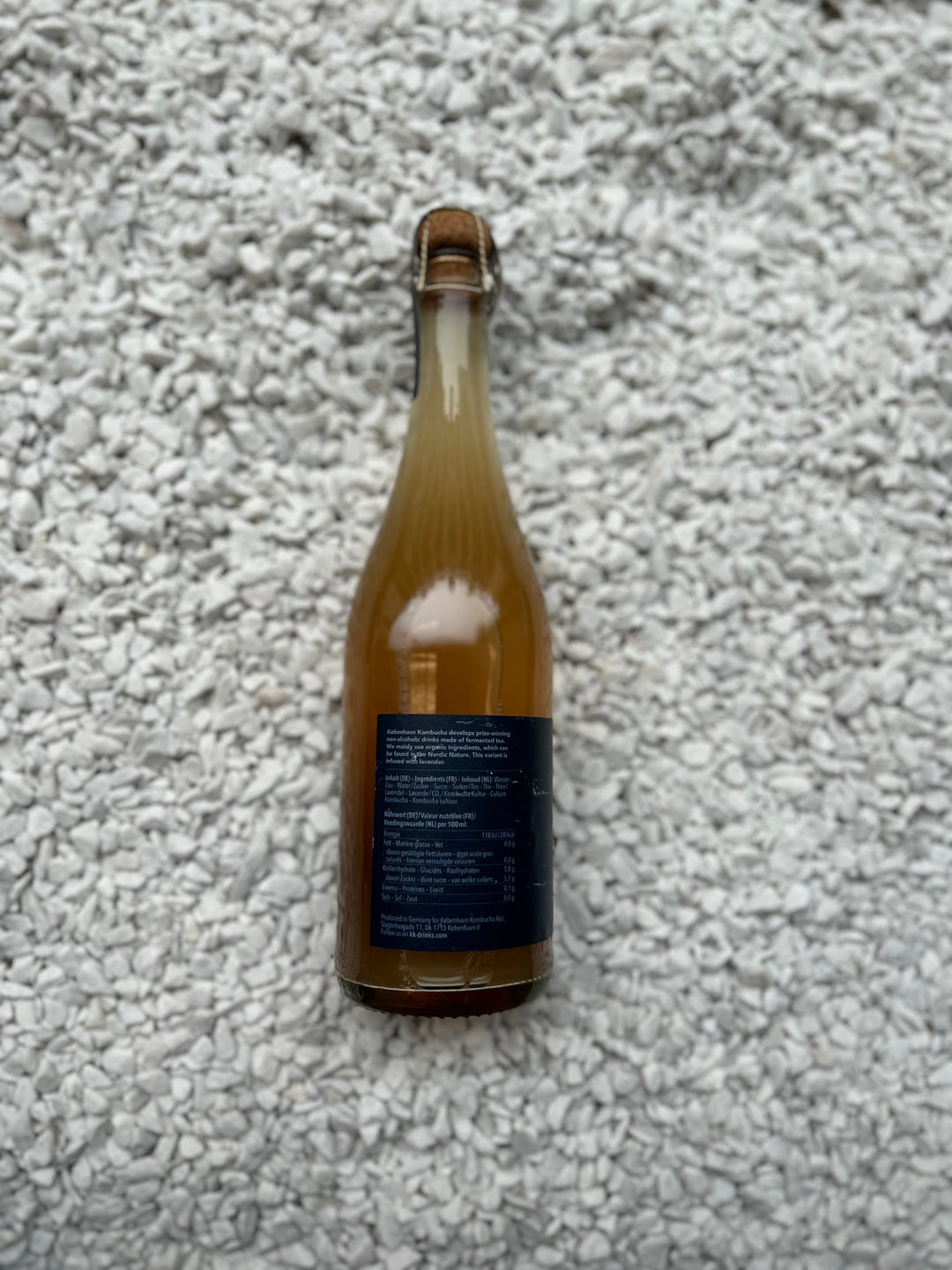 Flasche Hidcote Blue 0.00% von København Kombucha. Die schlanke Flasche hat ein minimalistisches Design mit einem blauen Etikett, das die alkoholfreie und erfrischende Natur der Kombucha-Getränksorte betont.