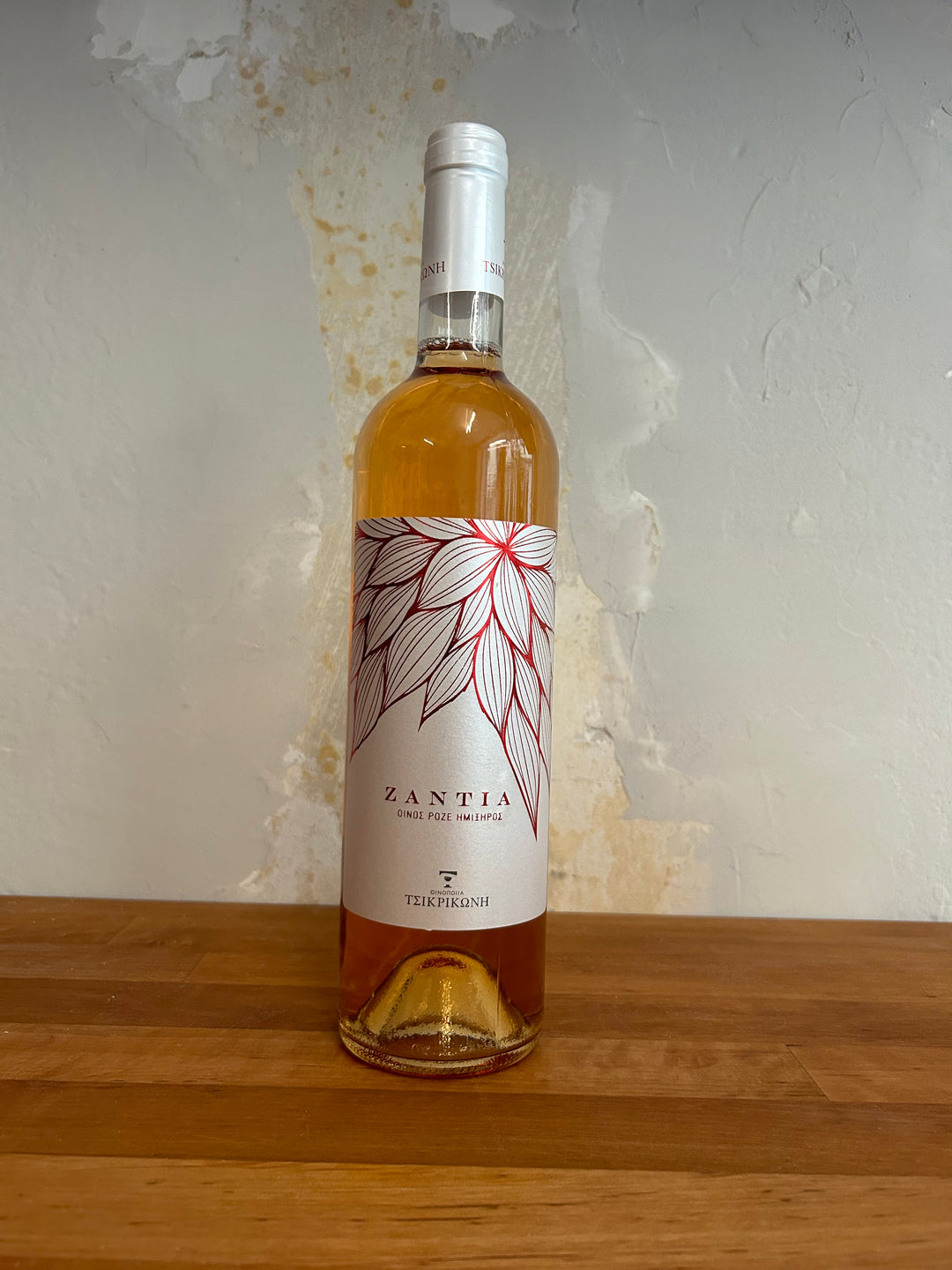 Flasche Tsikrikonis Winery Zantia 2022. Die stilvolle Flasche zeigt ein ansprechendes Etikett mit eleganter Schrift und einem modernen Design, das die fruchtigen Aromen und die Herkunft dieses griechischen Weins hervorhebt.